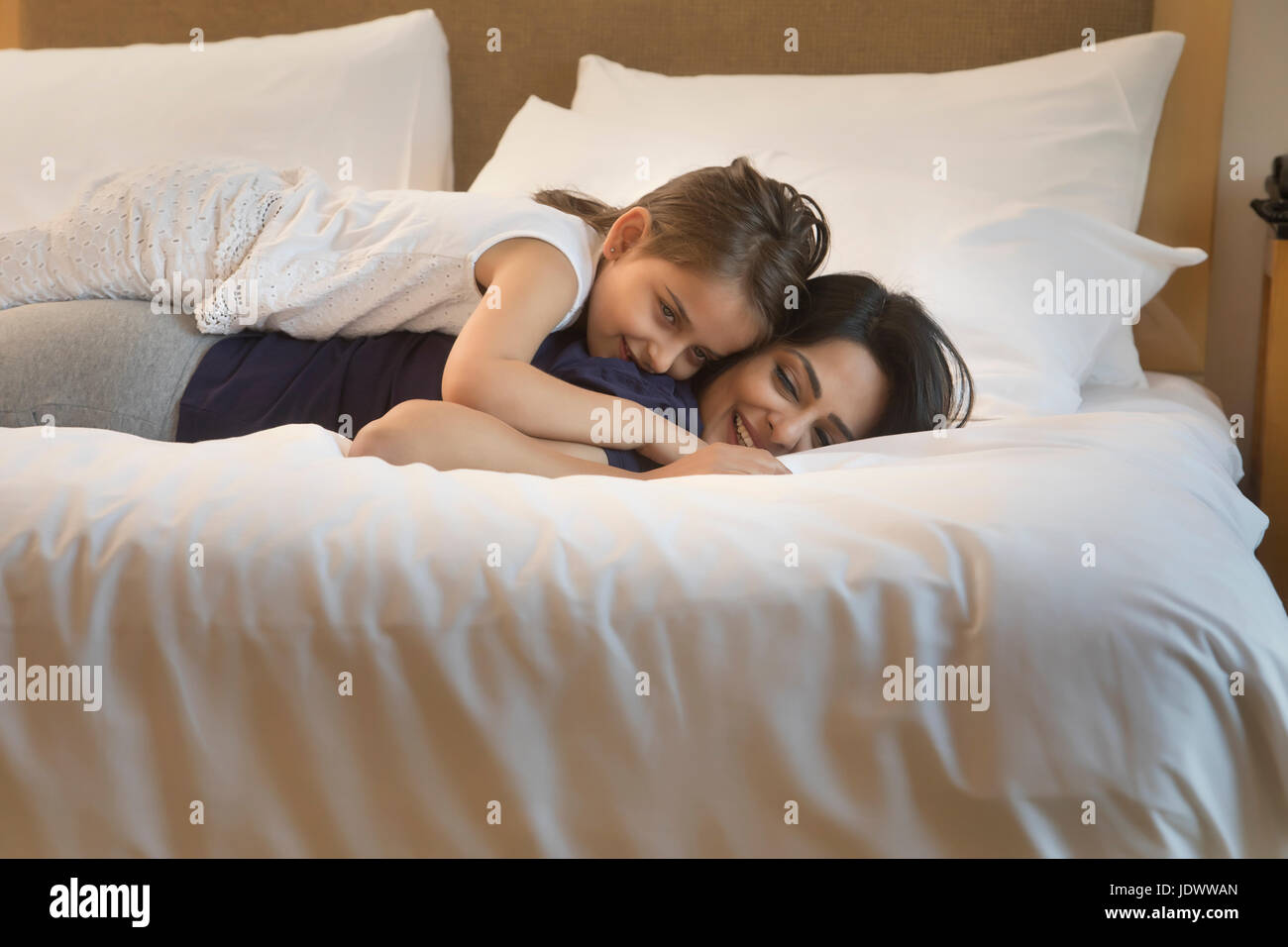 Madre e hija relajante en la cama Foto de stock