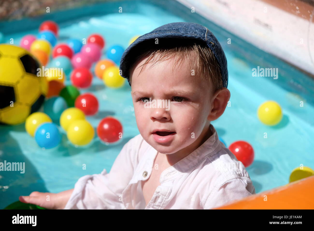 Un año de edad Baby Boy jugando en la piscina de chapoteo en día soleado Foto de stock
