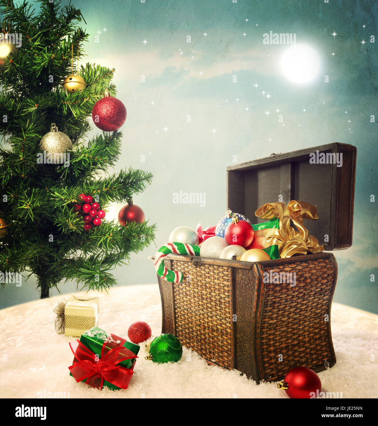 Caja de tesoro lleno de adornos de Navidad y regalos en la nieve con árbol  de Navidad Fotografía de stock - Alamy