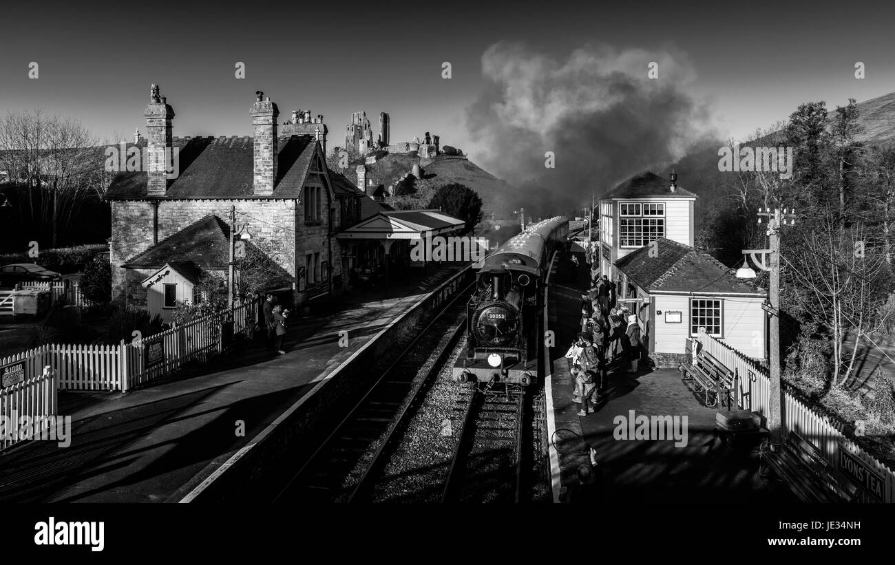 La imagen en blanco y negro de un tren a vapor en Swanage railway tomando a los pasajeros en la estación de tren el castillo Corfe, en Dorset, Reino Unido. Foto de stock