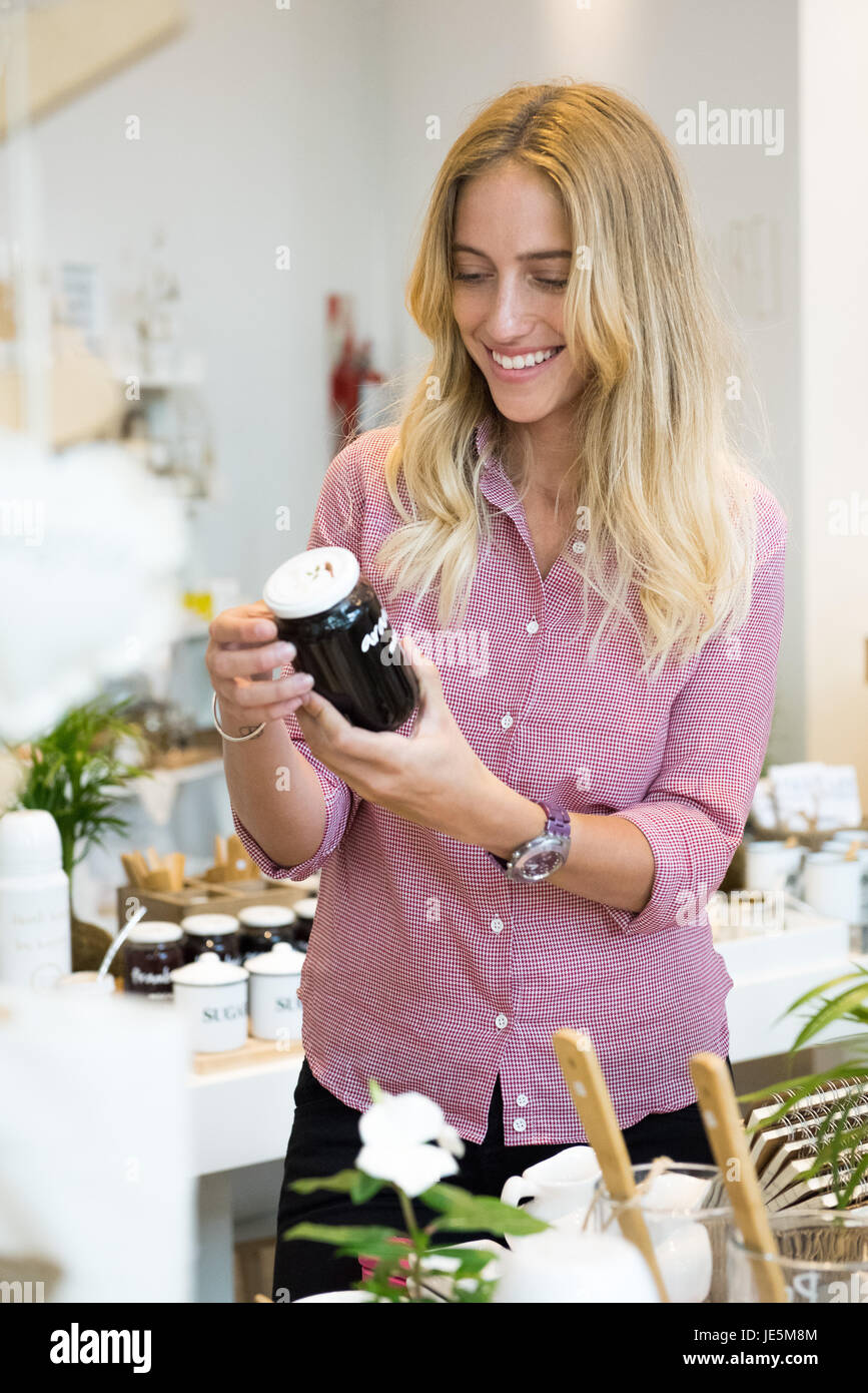 Mujer mirando tarro de conserva en la tienda Foto de stock