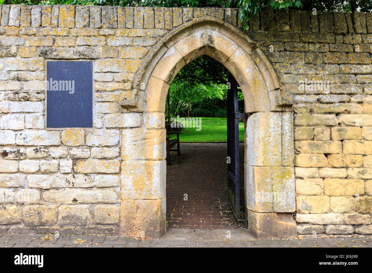 La entrada de la pared de piedra de Cotswold al jardín conmemorativo de Ernest Wilson, Chipping Campden, Inglaterra Foto de stock
