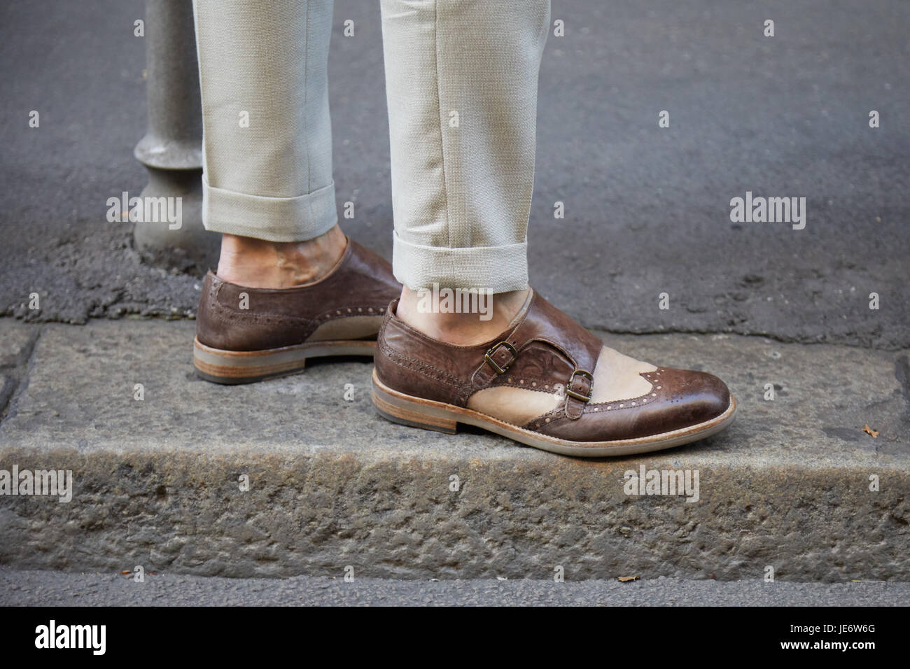 Milán - 17 DE JUNIO: Hombre con zapatos de cuero marrón y pantalones beige  antes de Versace