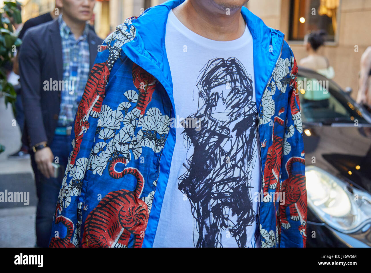 Milán - 17 DE JUNIO: Hombre con chaqueta azul con decoración oriental tigre  naranja antes de Versace