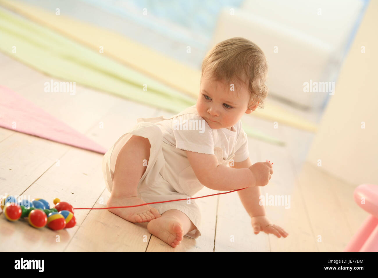 Bebé, de 11 meses, juguetes de madera, Caterpillar, jugar Nachziehtier, vestidos, rubia, aprender, pocas esclusas, descubrimientos, Interiores, boy, monos, niña, curiosamente, concentración, sentarse, bebé, juguetes, juguetes, Foto de stock