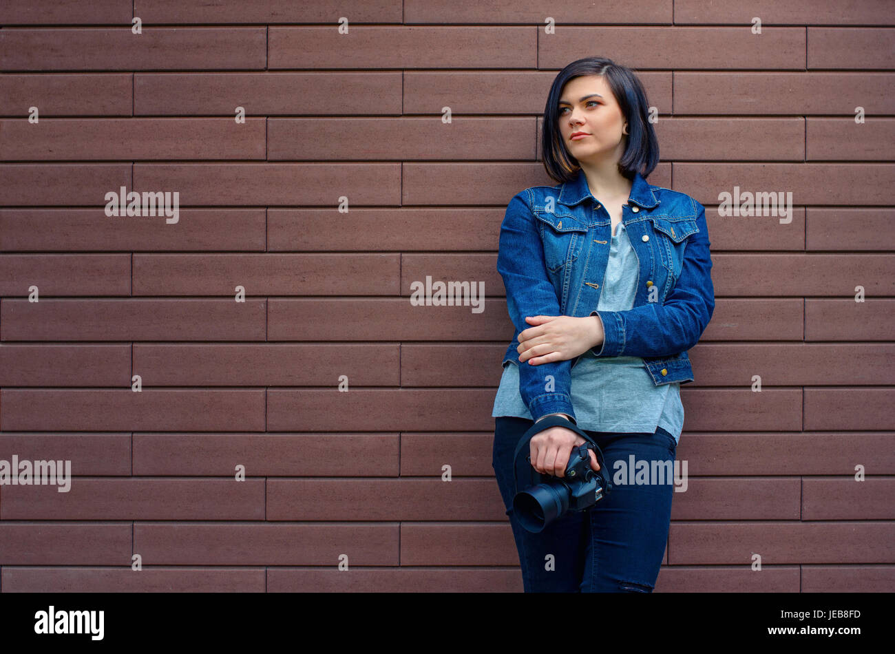 Hermosa mujer en chaqueta con estilo militar cerca de la pared de ladrillo