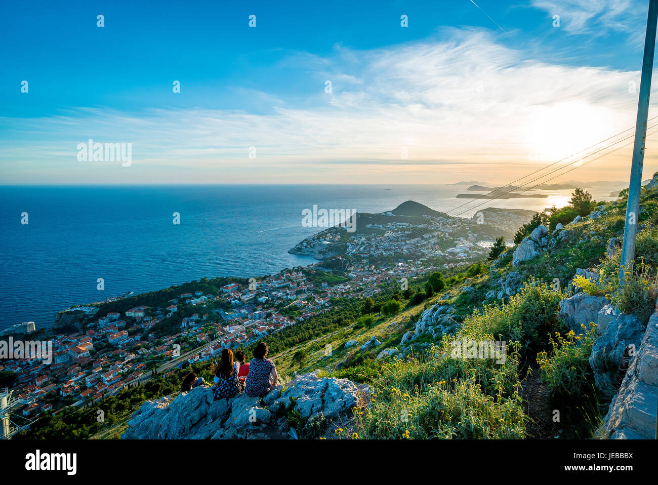 Los turistas observan la puesta de sol sobre el mar Adriático desde la cima del monte Srd, Dubrovnik. Foto de stock