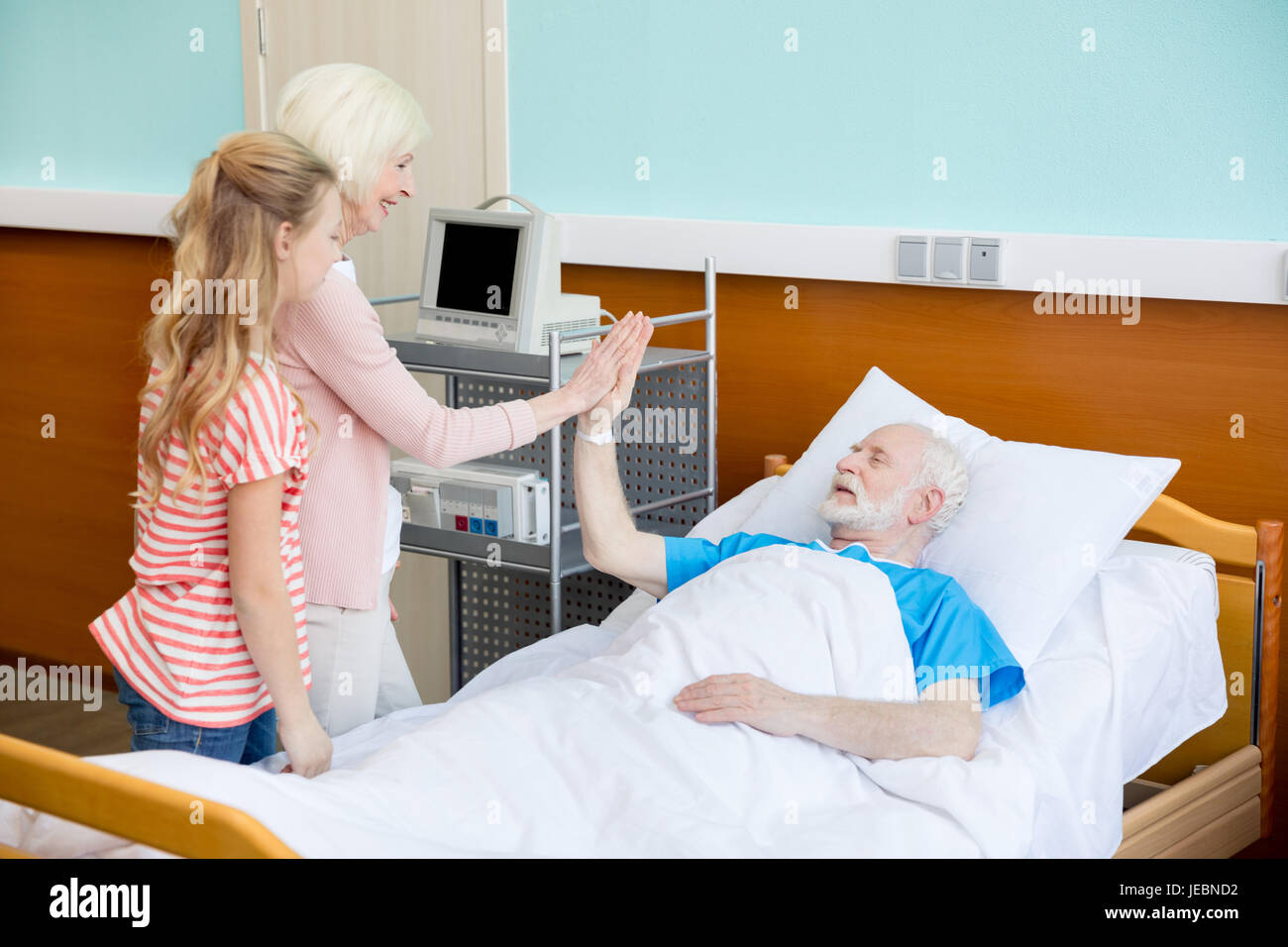 Abuela y nieta visitando pacientes en hospital. Paciente varón en concepto  de cama hospitalaria Fotografía de stock - Alamy