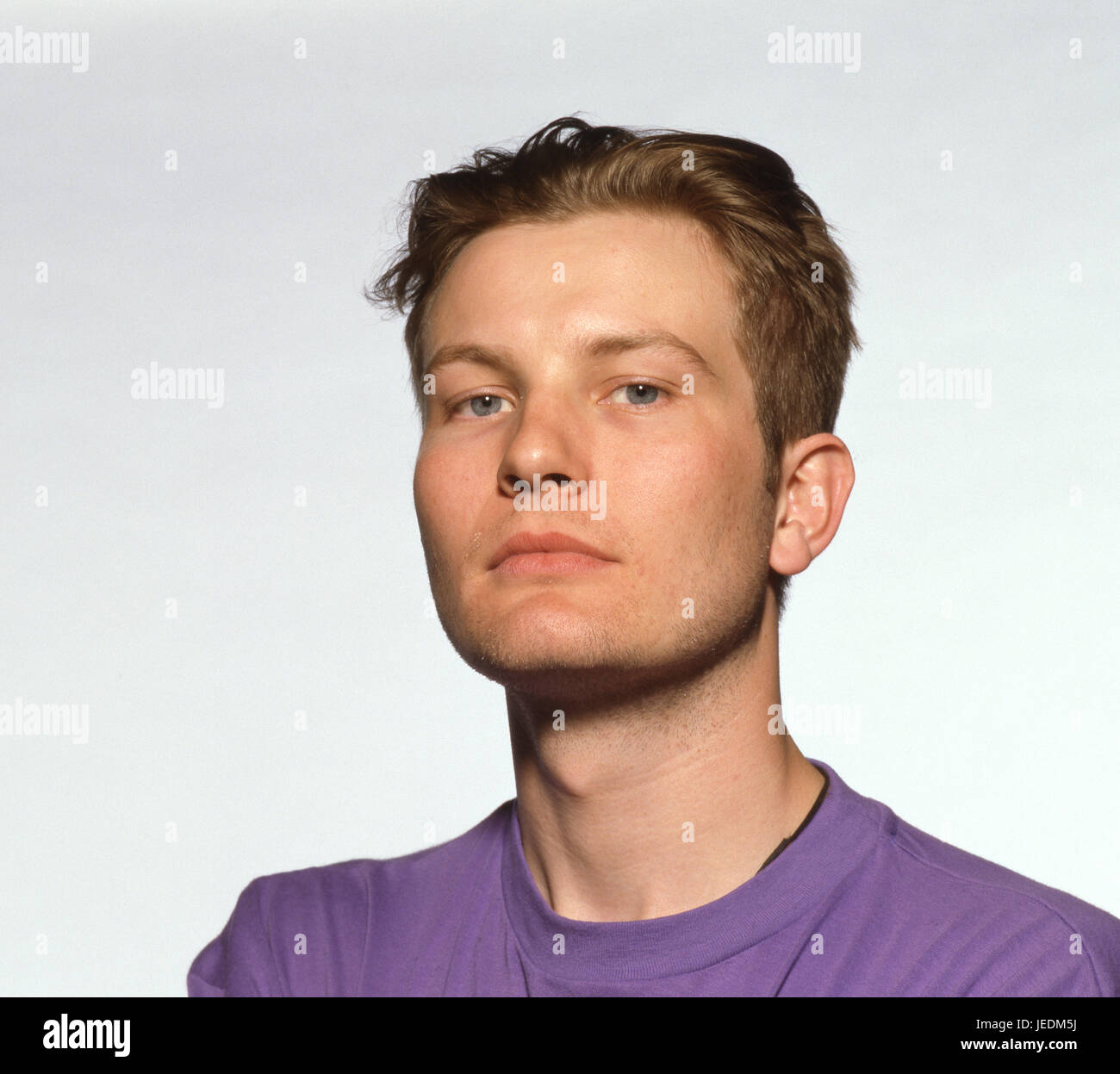 Retrato de un joven en una camiseta púrpura Foto de stock