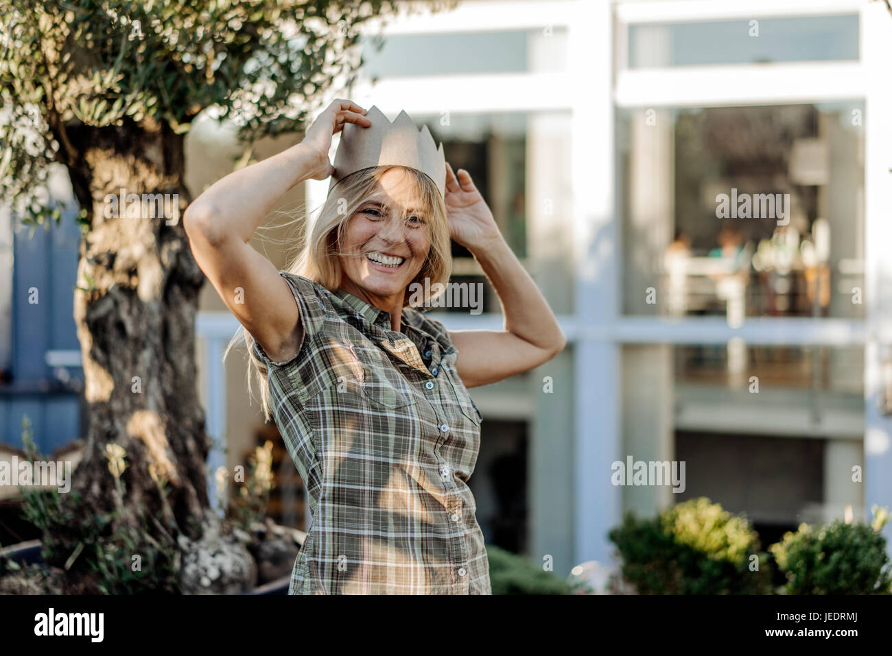 Mujer feliz en el jardín una corona Foto de stock