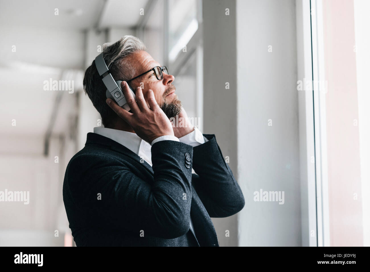 Empresario llevar auriculares , escuchar música Foto de stock