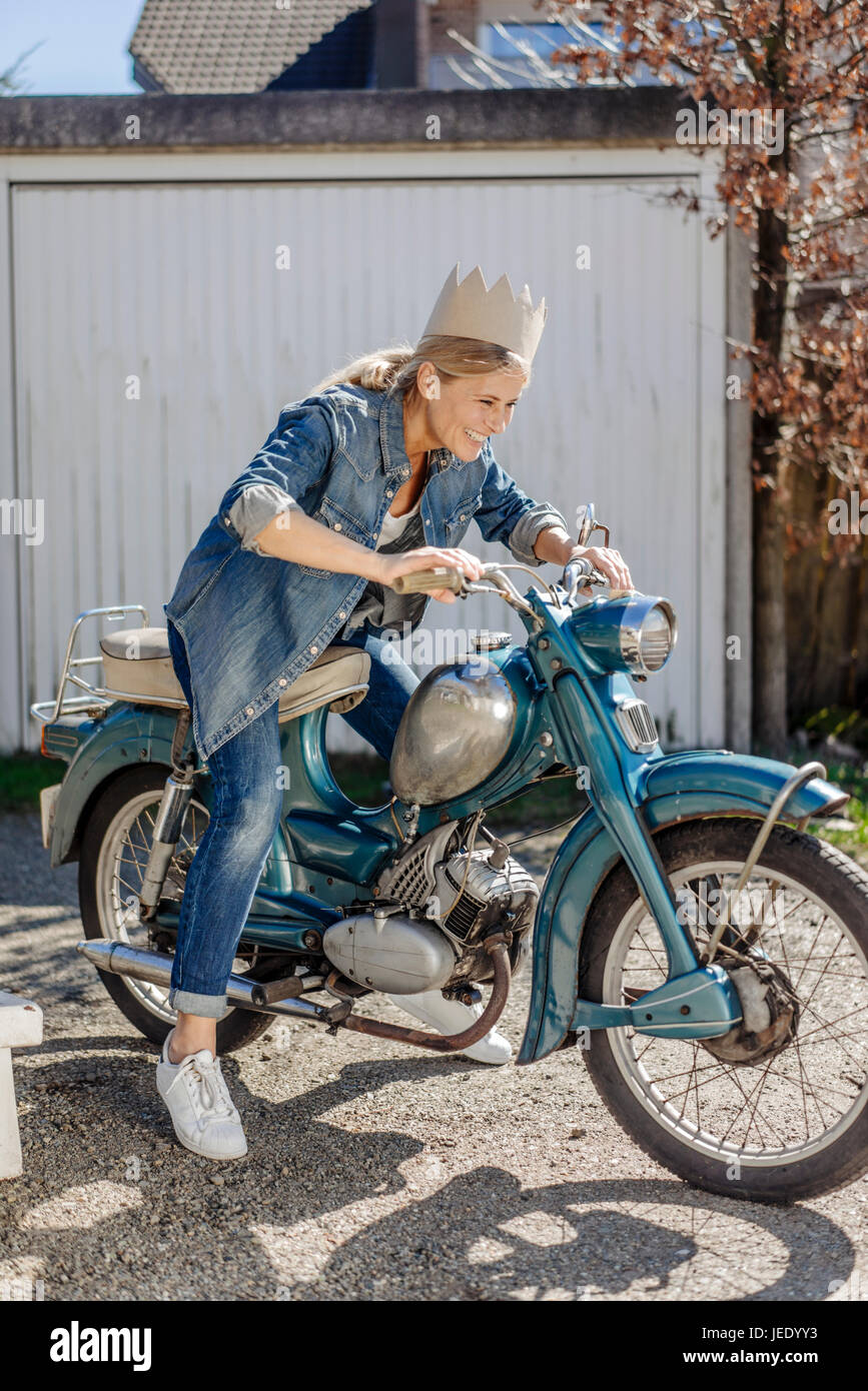Feliz mujer en motocicleta vintage una corona Foto de stock