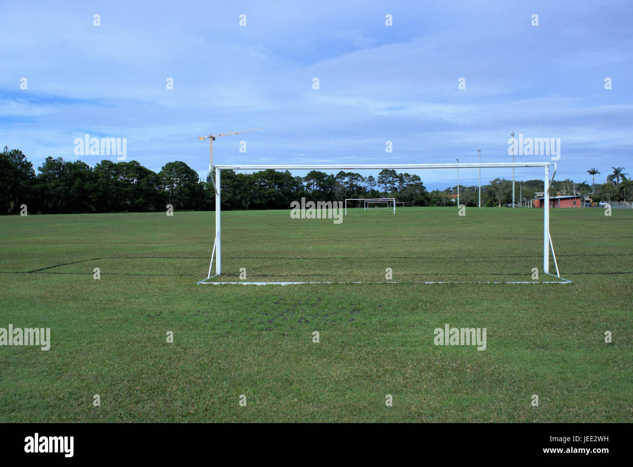 Juegos de fútbol en Australia. Juegos de fútbol con la portería, luces de inundación, árboles y una grúa en la distancia. Foto de stock