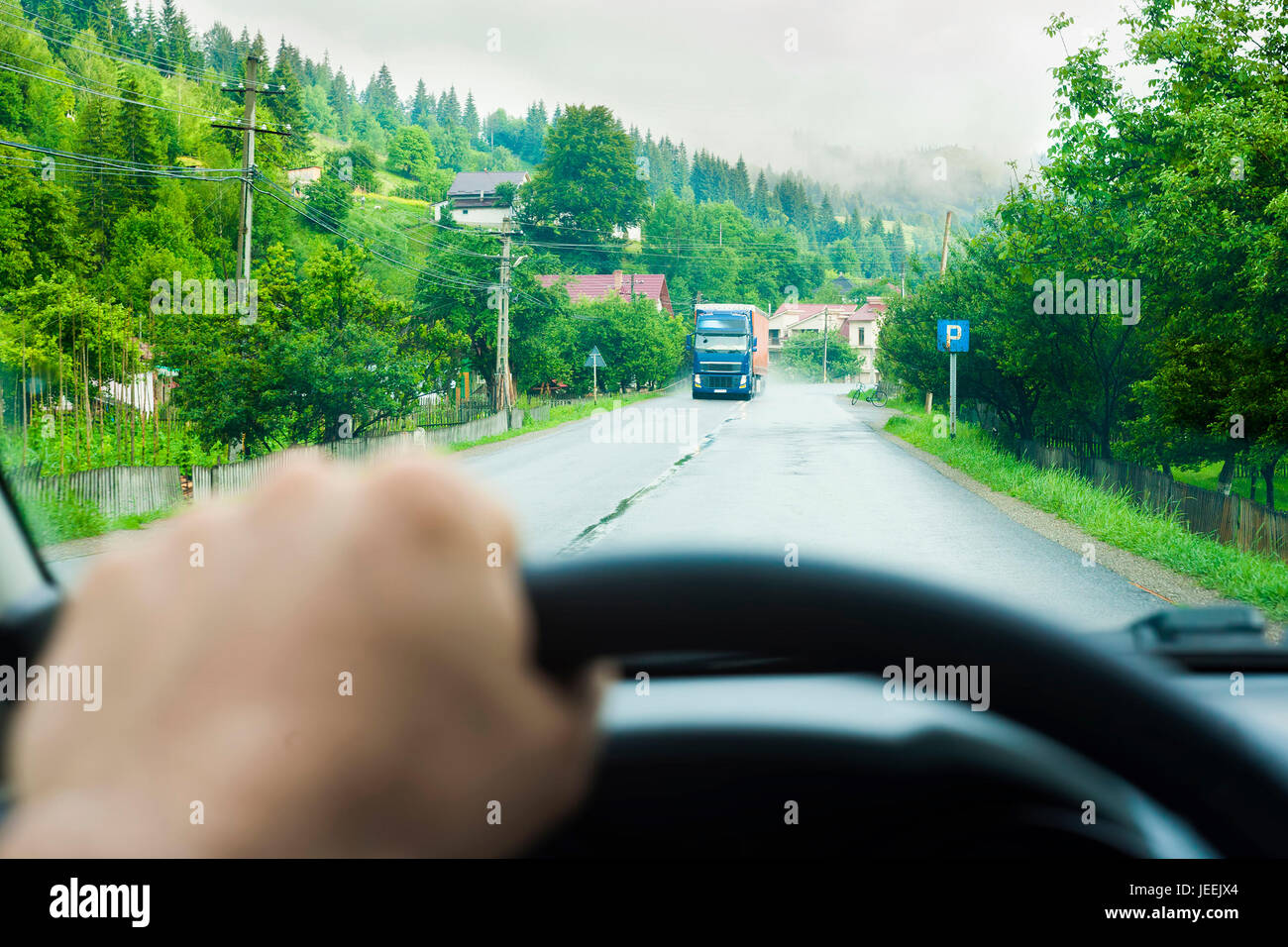 Vista de la carretera y la mano en la rueda de coche, focus sobre antecedentes Foto de stock