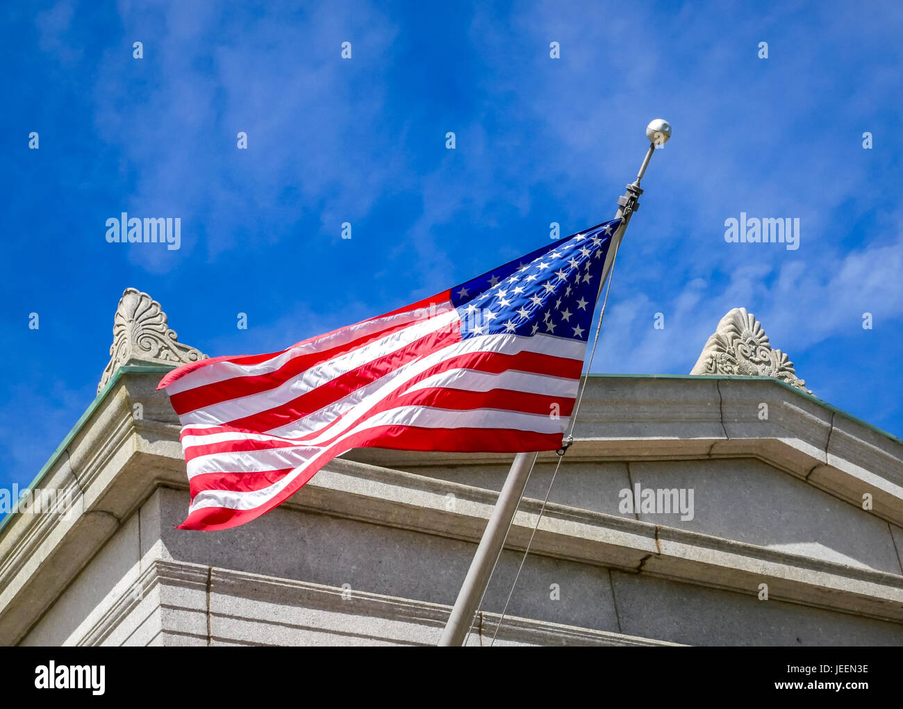 Cerca de bandera americana ondeando contra el cielo azul, el Bunker hill Monument, Charlestown, Boston, Massachusetts, EE.UU. Foto de stock