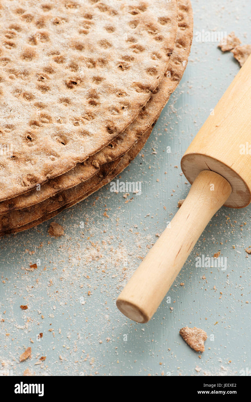 Pan plano sueco de cerca. Pan tostado escandinavo y rolling pin redondo en la mesa de la cocina. Foto de stock