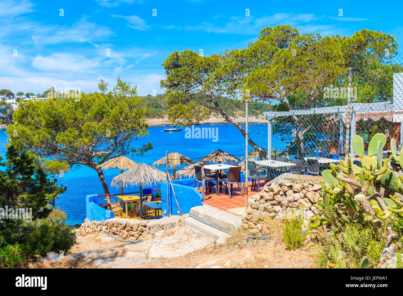 Vista del pequeño restaurante en el acantilado costero en la bahía de Cala Portinatx, Ibiza, España. Foto de stock