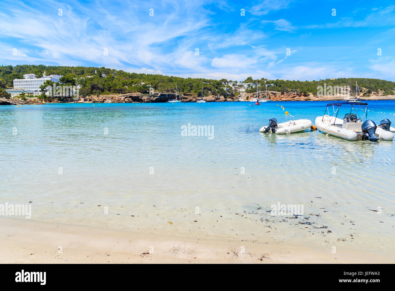 Balsa de embarcaciones a motor en el agua en la playa de Cala Portinatx,  Ibiza, España Fotografía de stock - Alamy
