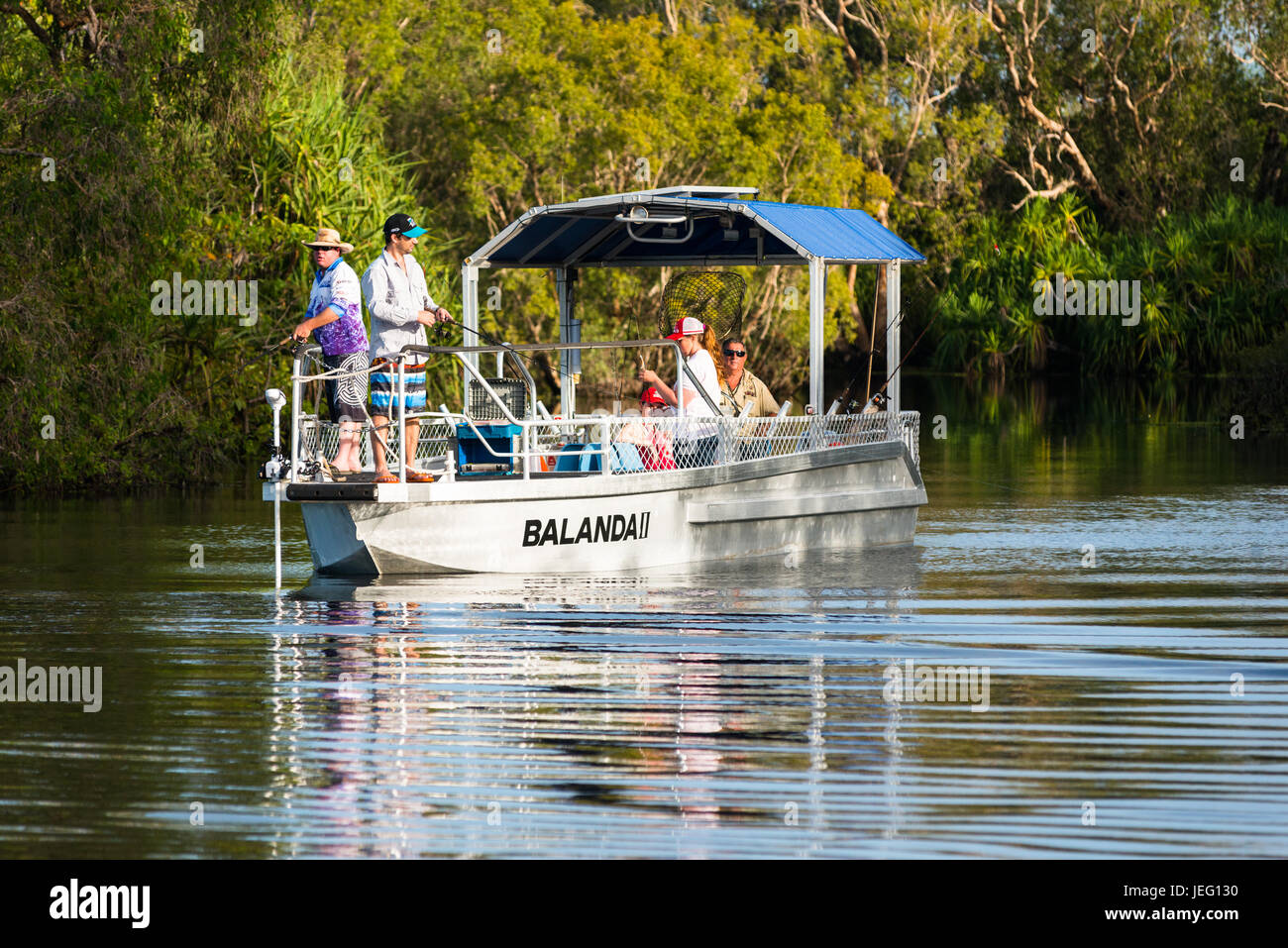 Un barco con turistas la pesca en agua amarilla, el Parque Nacional Kakadu, en Australia. Foto de stock