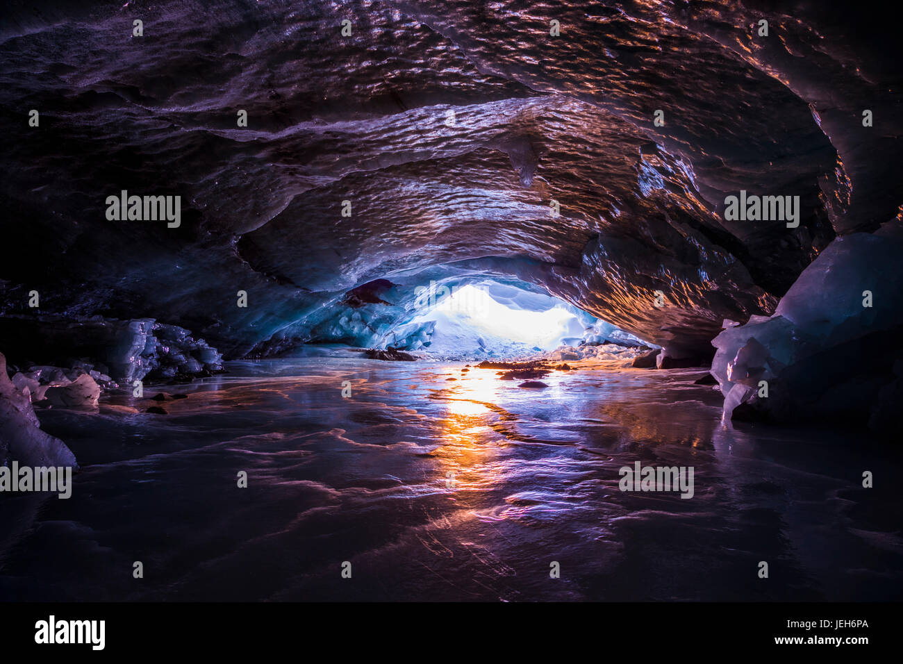 Los colores de la puesta de sol se reflejan en el hielo dentro de una cueva de hielo dentro de Augustana glaciar en la Cordillera de Alaska en invierno, Alaska, Estados Unidos de América Foto de stock