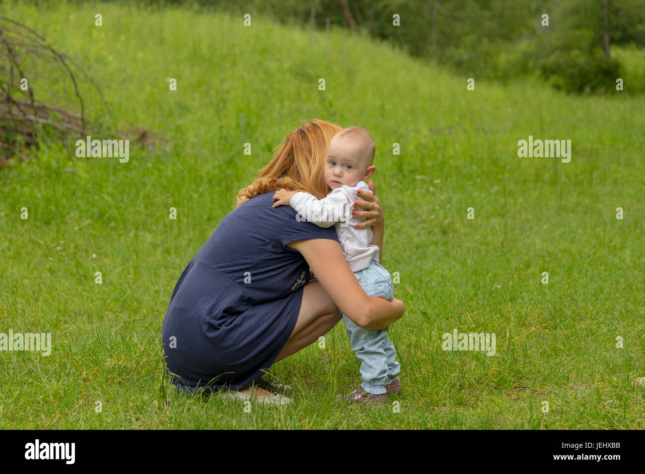 Baby Girl embrassing su madre para protección Foto de stock