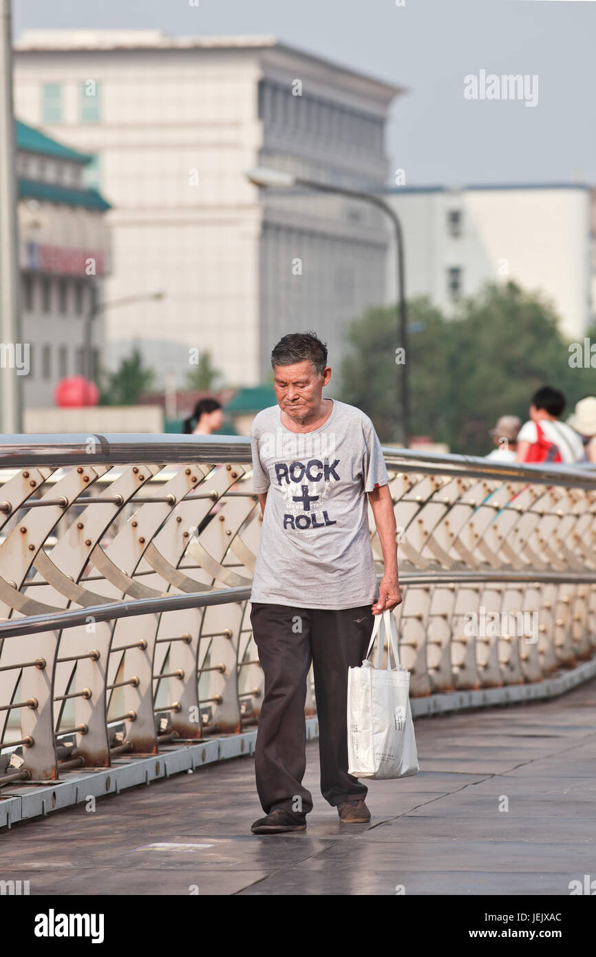 BEIJING-24 DE JULIO DE 2015. Paseos de edad avanzada en el puente peatonal. La población mayor de China (60 años o más) es actualmente de unos 128 millones. Foto de stock
