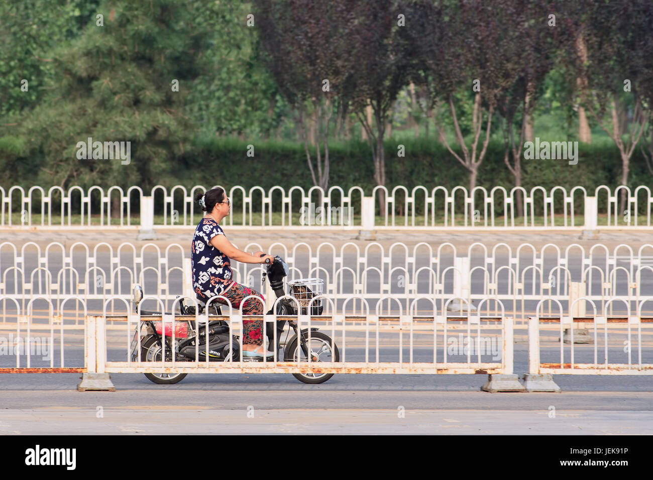 PEKÍN-AGO. 5, 2015. Mujer China en e-bike. En una década, las bicicletas electrónicas en China subieron de casi cero a más de 150 millones (2015). Foto de stock