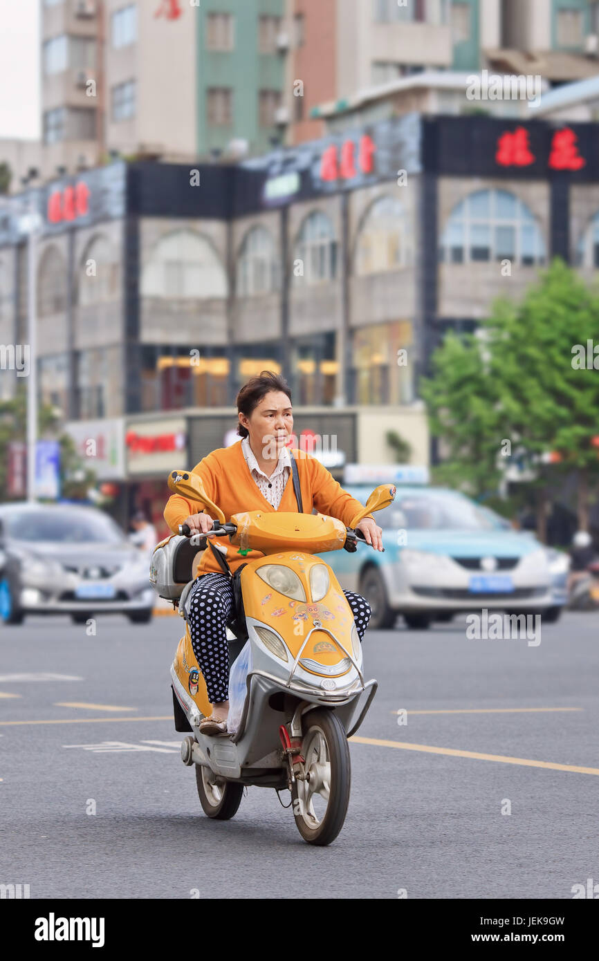 KUNMING-30 DE JUNIO DE 2014. Mujer en bicicleta eléctrica amarilla. Muchas bicicletas  eléctricas en China son el estilo scooter e-bike que puede o no tener  pedales Fotografía de stock - Alamy