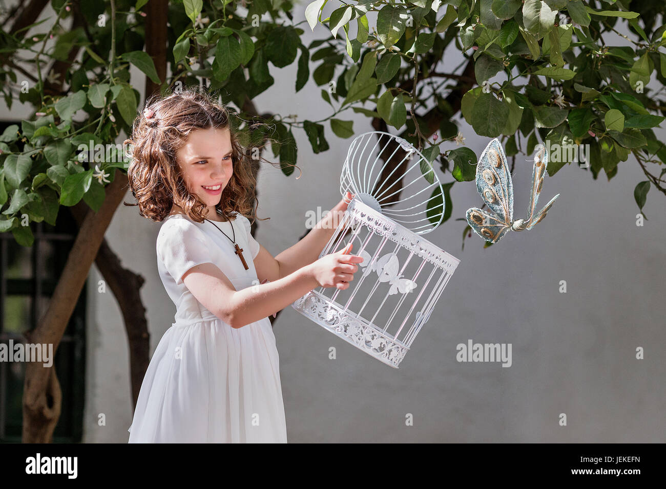 Chica liberando una mariposa de su jaula Foto de stock