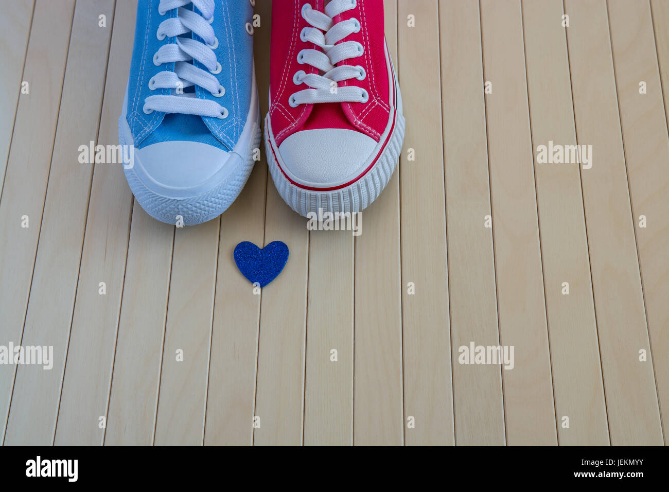 Azul y rojo zapatillas con un coraz n azul en el fondo de madera