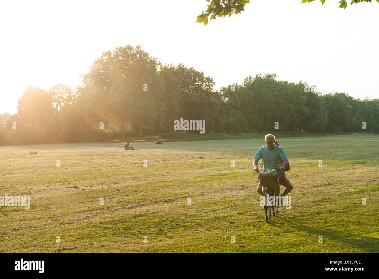 Una escena feliz en el sol como un chico y una chica compartir un paseo en bicicleta Foto de stock