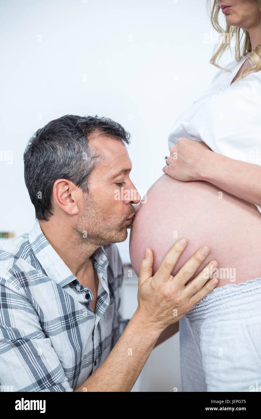 El hombre besando el vientre de la mujer embarazada Foto de stock