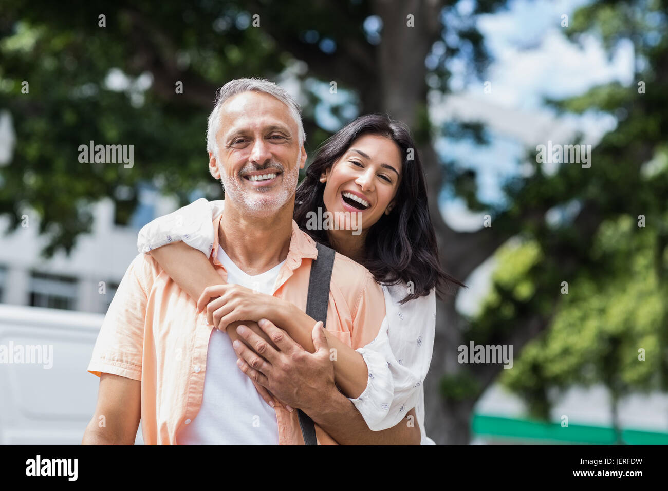 Mujer hombre feliz abrazando desde atrás Foto de stock