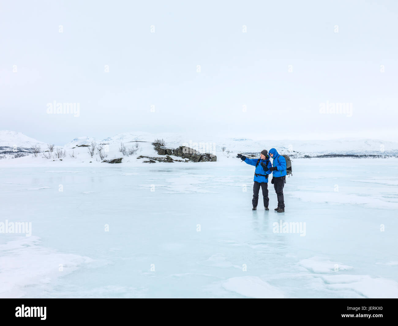 Hombres de pie sobre el hielo Foto de stock