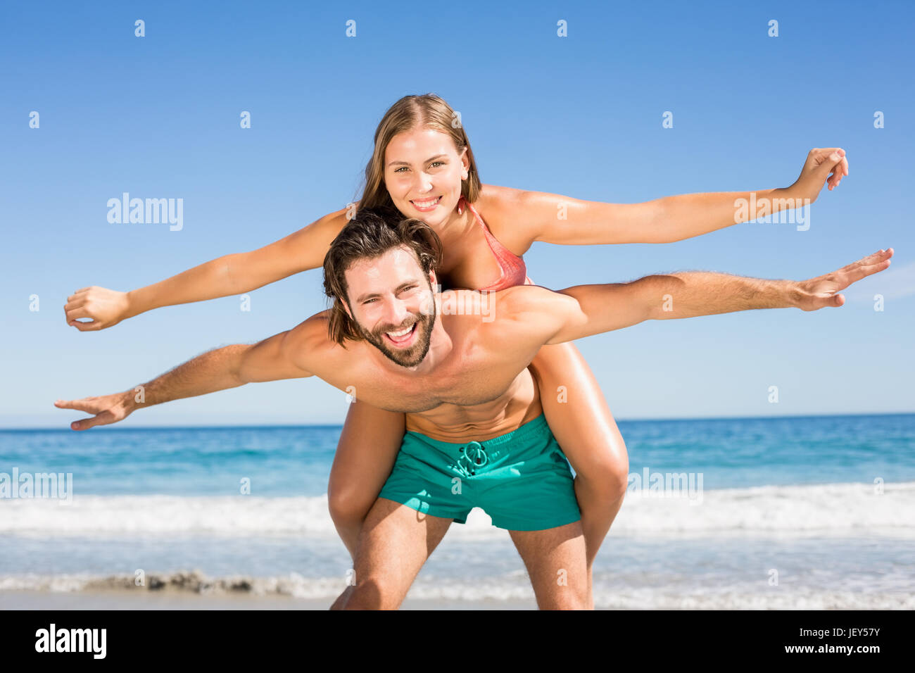 Hombre haciendo piggy back ride para mujer Foto de stock