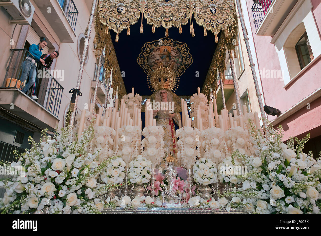 Parte delantera con velas, flores y tejido bordado del trono de la Nuestra Se-ora del Amor Hermoso, Linares, provincia de Jaén, España Foto de stock