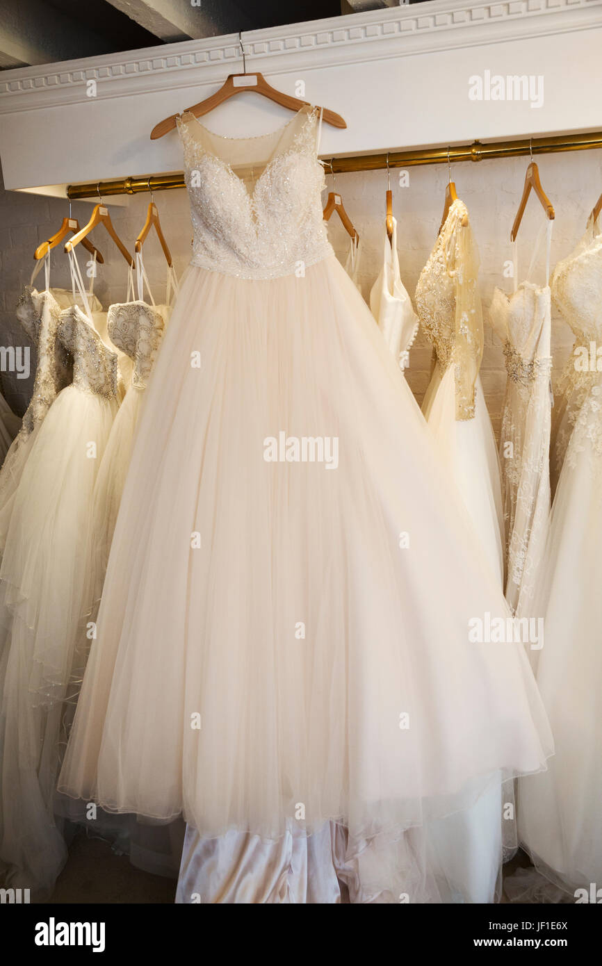 Filas de vestidos de novia en exhibición en una tienda de vestidos de boda  especialista. Un vestido blanco en una percha con una falda neto total  Fotografía de stock - Alamy