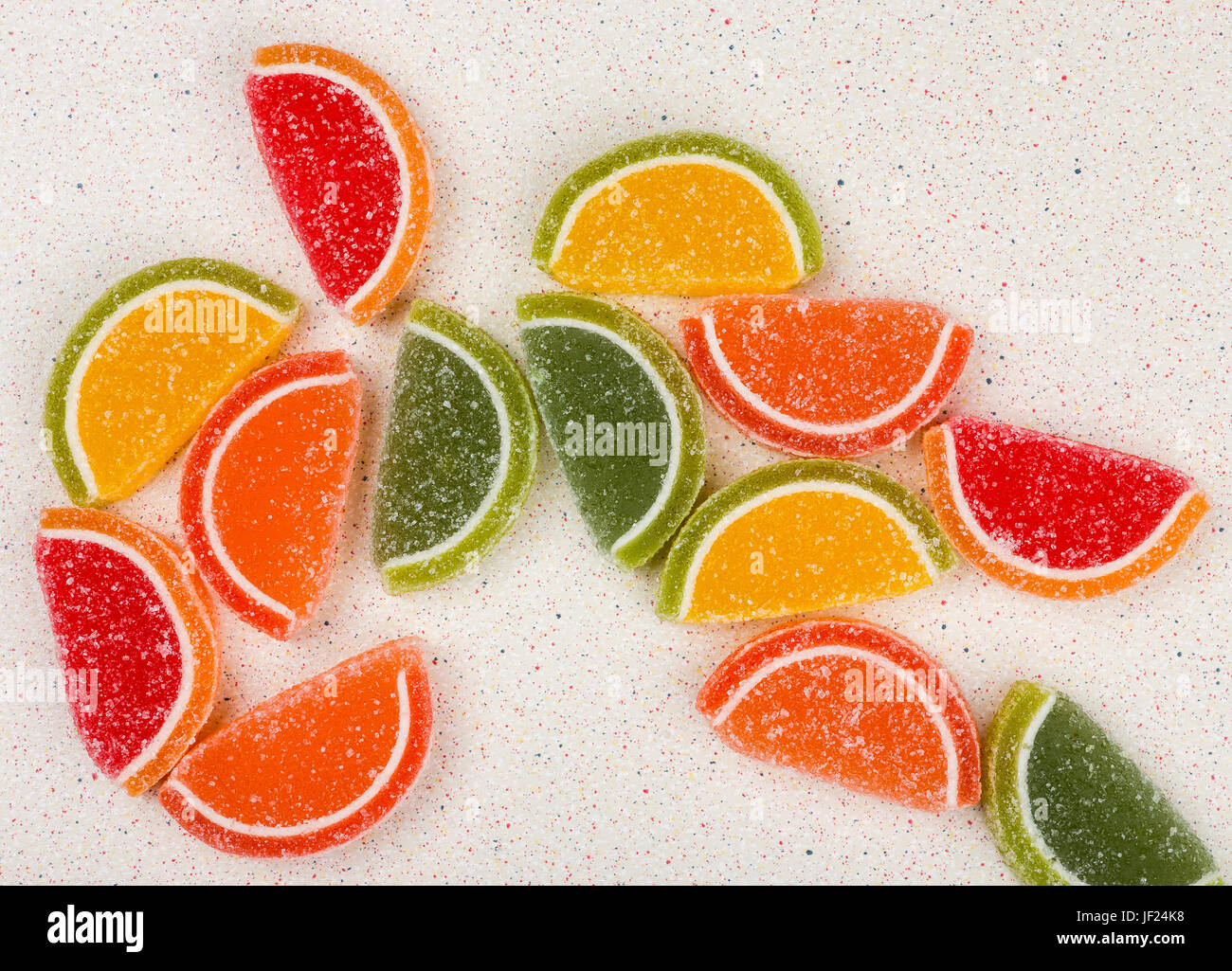 Jalea de frutas multicolores en forma de frutas dispersos al azar sobre un  tablero gris Fotografía de stock - Alamy