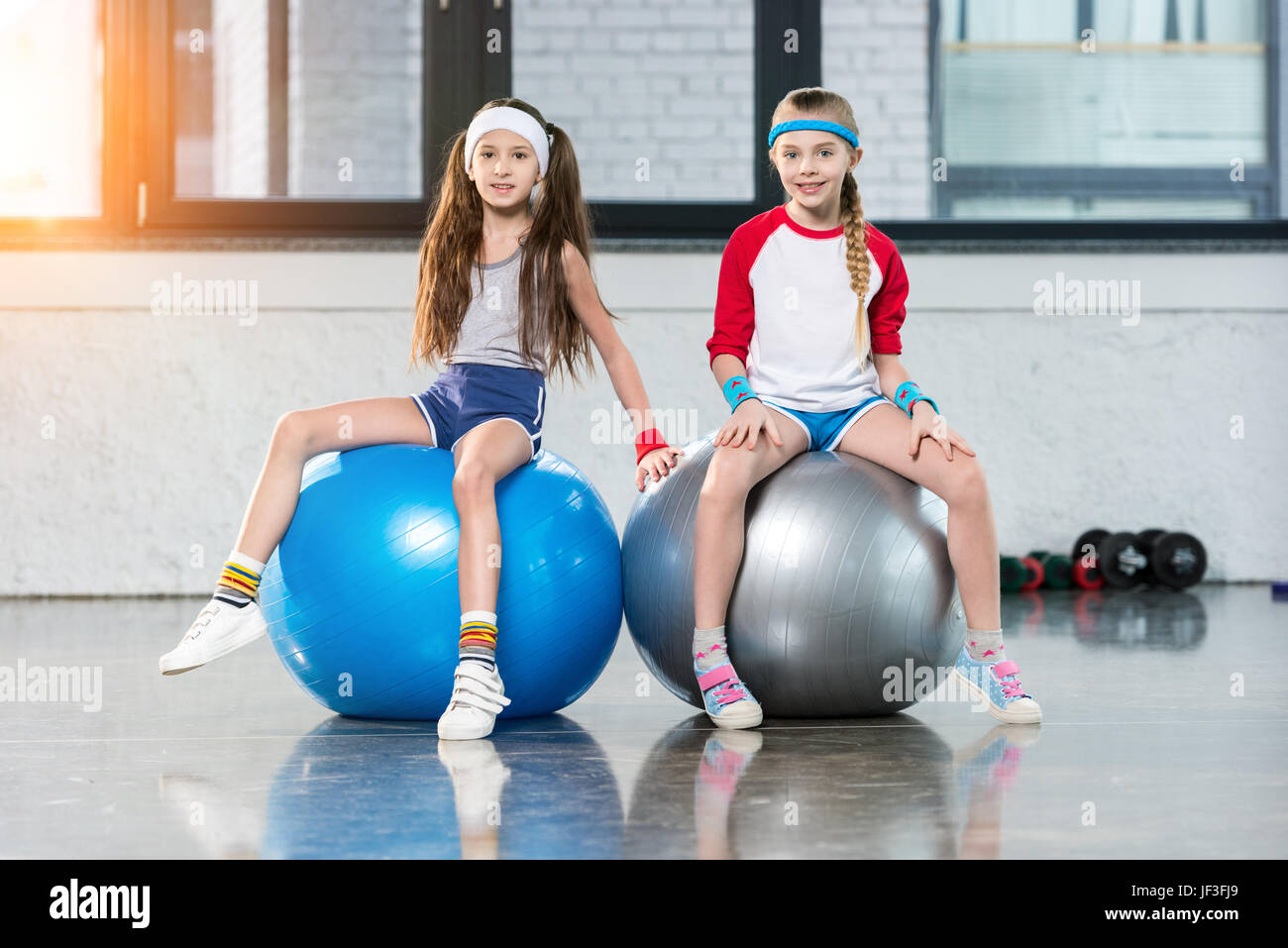 Dos niñas en ropa deportiva sentado fitness studio, los niños DEPORTE CONCEPTO Fotografía de stock - Alamy