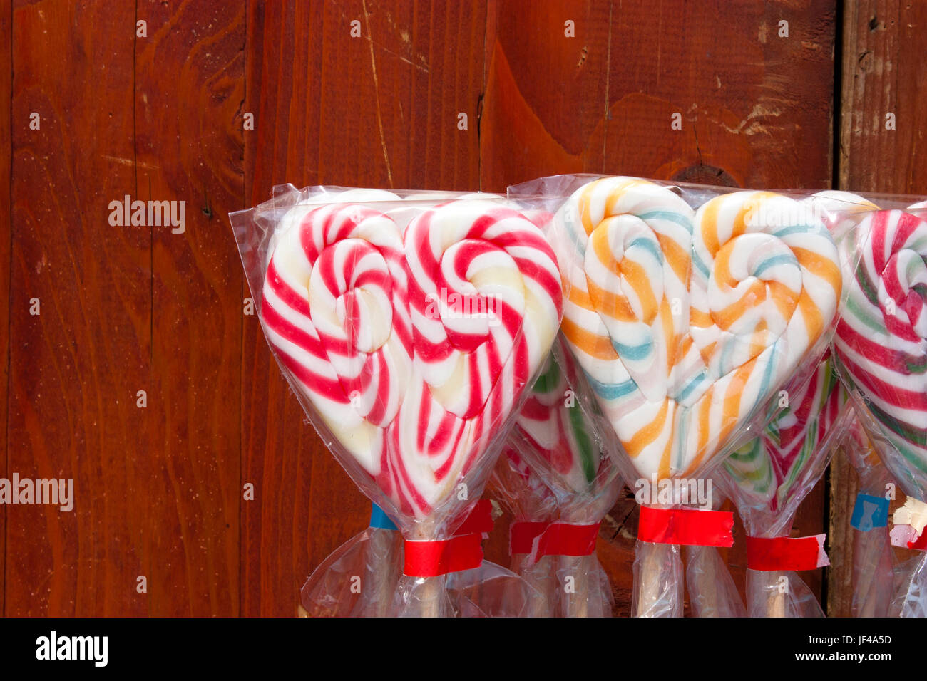 En forma de corazón multicolor lolly pops envuelto en celofán, detaill Foto de stock