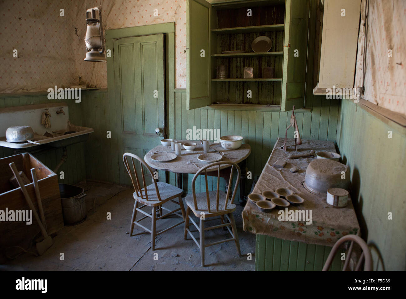 Una cocina con comer en el comedor de una casa abandonada en la ciudad fantasma de Bodie. Foto de stock