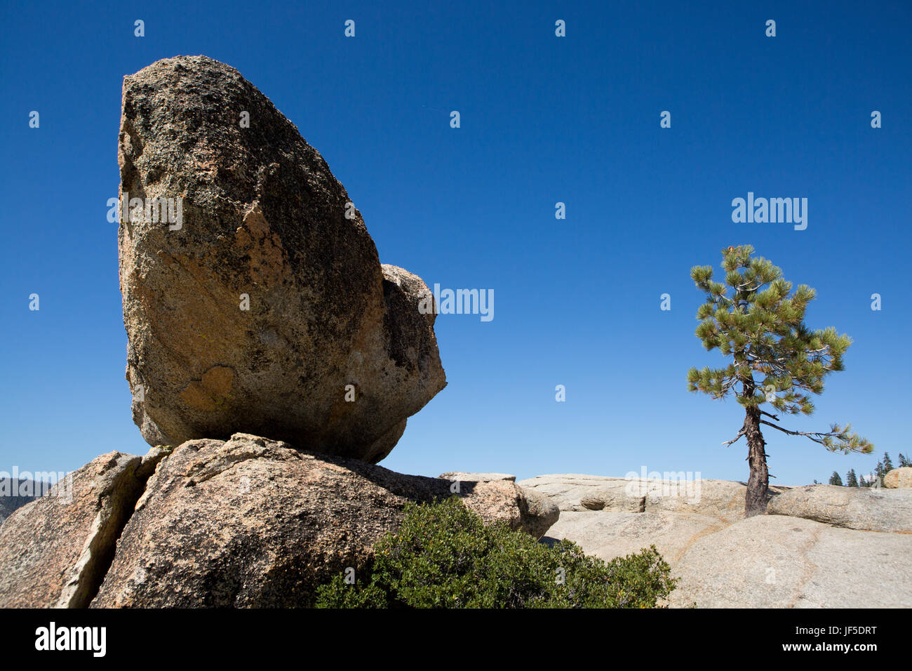 En Taft punto pico, una gran roca descansa sobre una cornisa que conduce al valle de Yosemite a continuación. Foto de stock