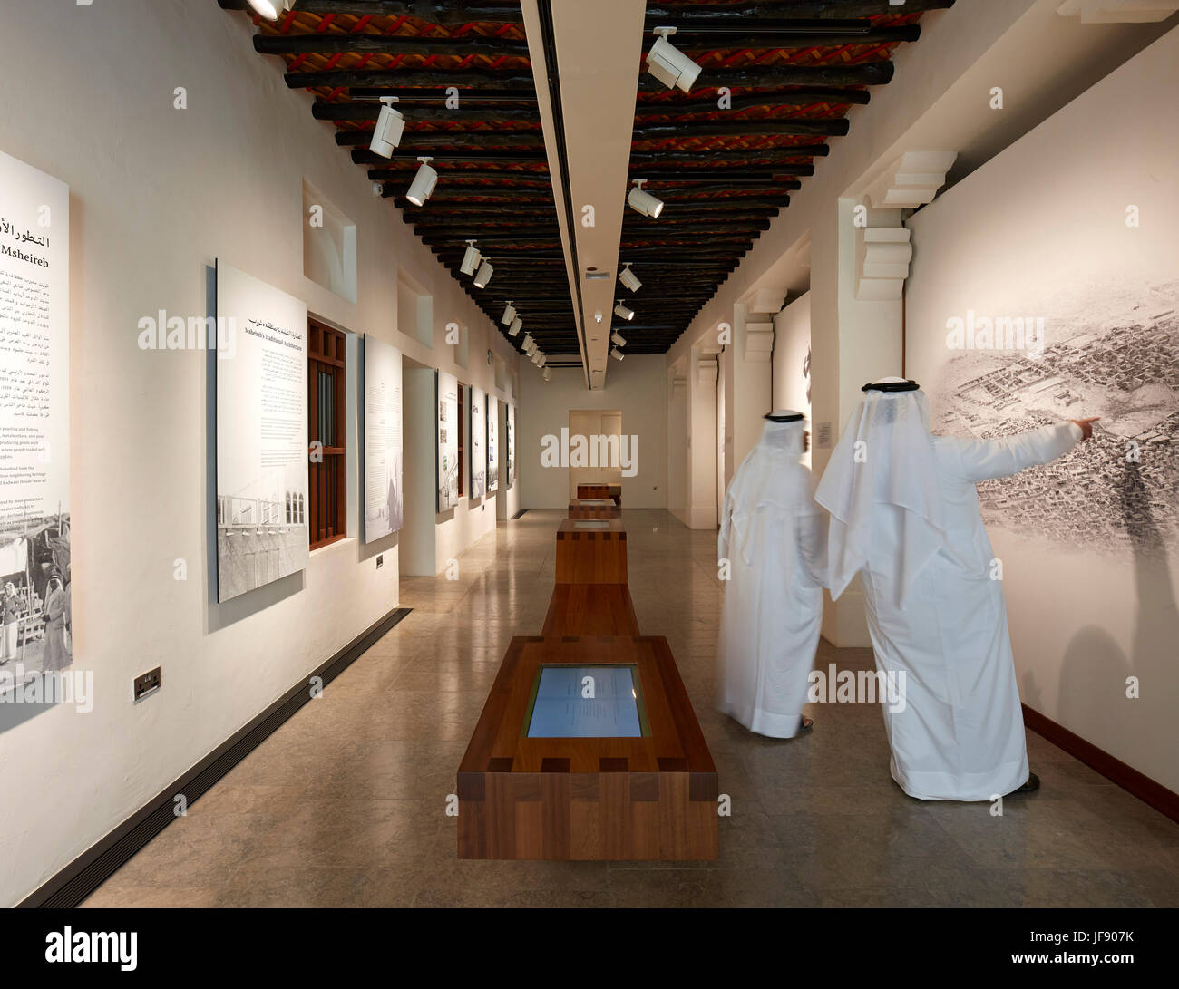 Vista interior con el hombre local en el tradicional vestido de Qatar. Mohammed Bin Jassim House, Doha, Qatar. Arquitecto: John McAslan & Partners, 2017. Foto de stock