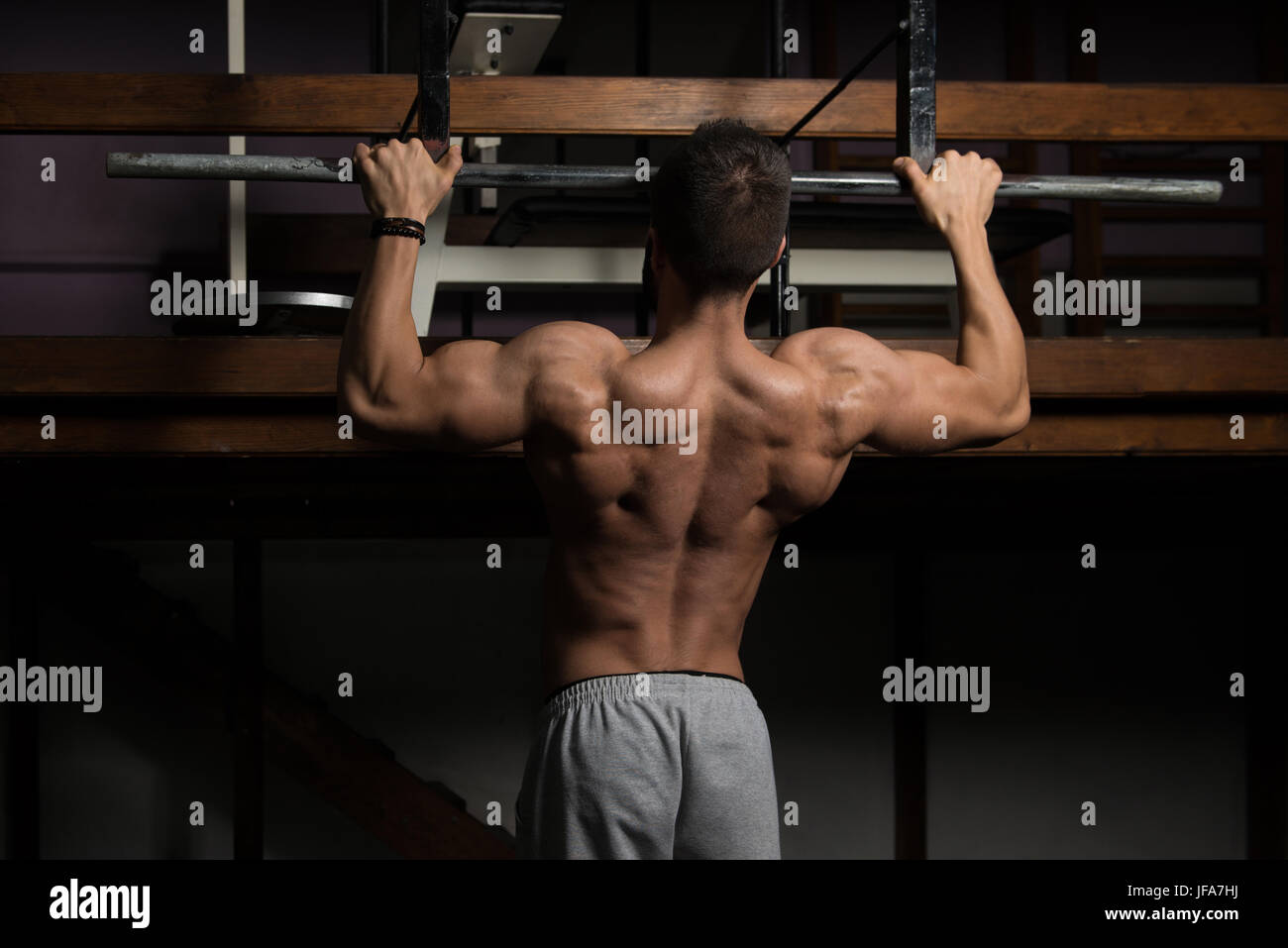 Hombre deportista haciendo tirar ups - Chin-Ups en el gimnasio. Foto de stock