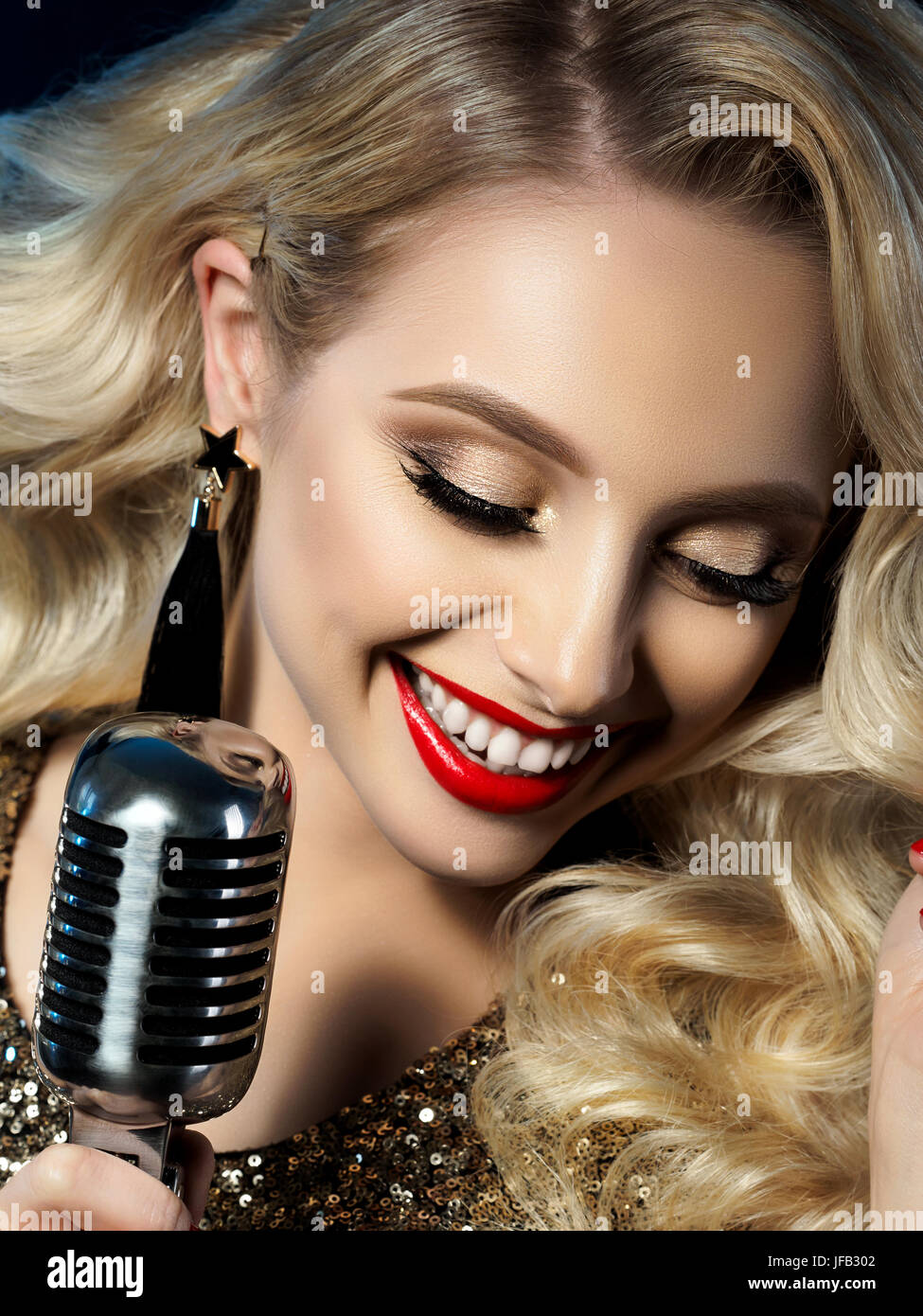 Close Up retrato de bonita rubia cantante manteniendo el estilo retro del  micrófono. Hermosa maquillaje con labios rojos. Concierto, karaoke,  celebridad, musical Fotografía de stock - Alamy