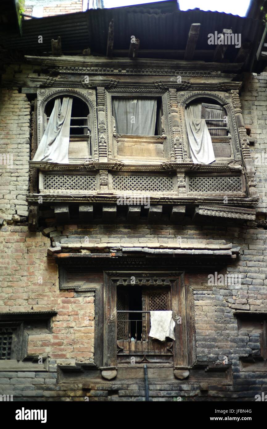 Exterior de un edificio Newari con ventanas de madera antigua y decoraciones. Foto de stock