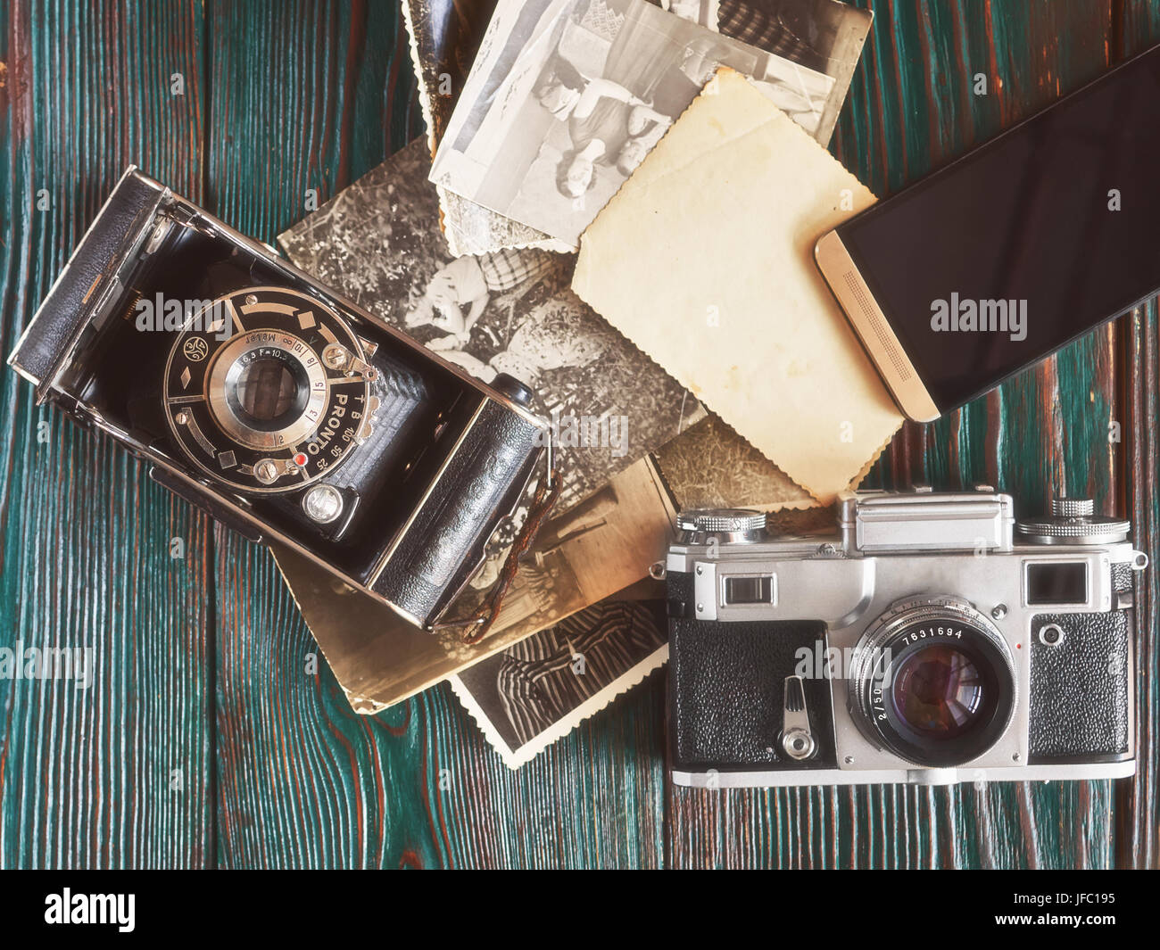 Tres generaciones de cámaras fotográficas y viejas fotos en la memoria. El  antiguo fondo de madera auténtica Fotografía de stock - Alamy