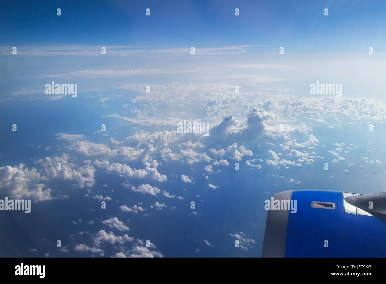 Ala de avión a través de un azul y cielo nublado Foto de stock