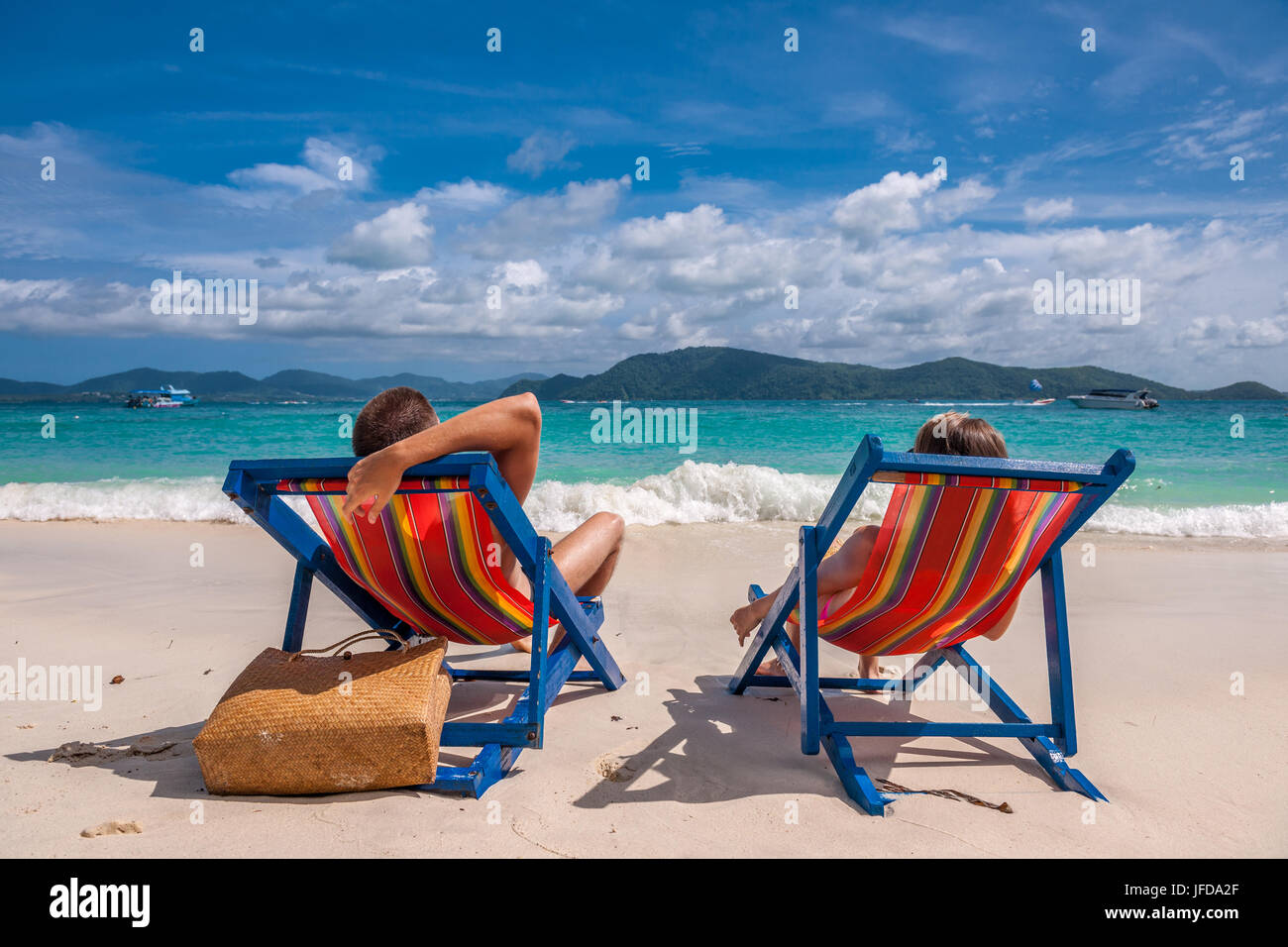 Pareja en playa tropical en reposeras Fotografía de stock - Alamy