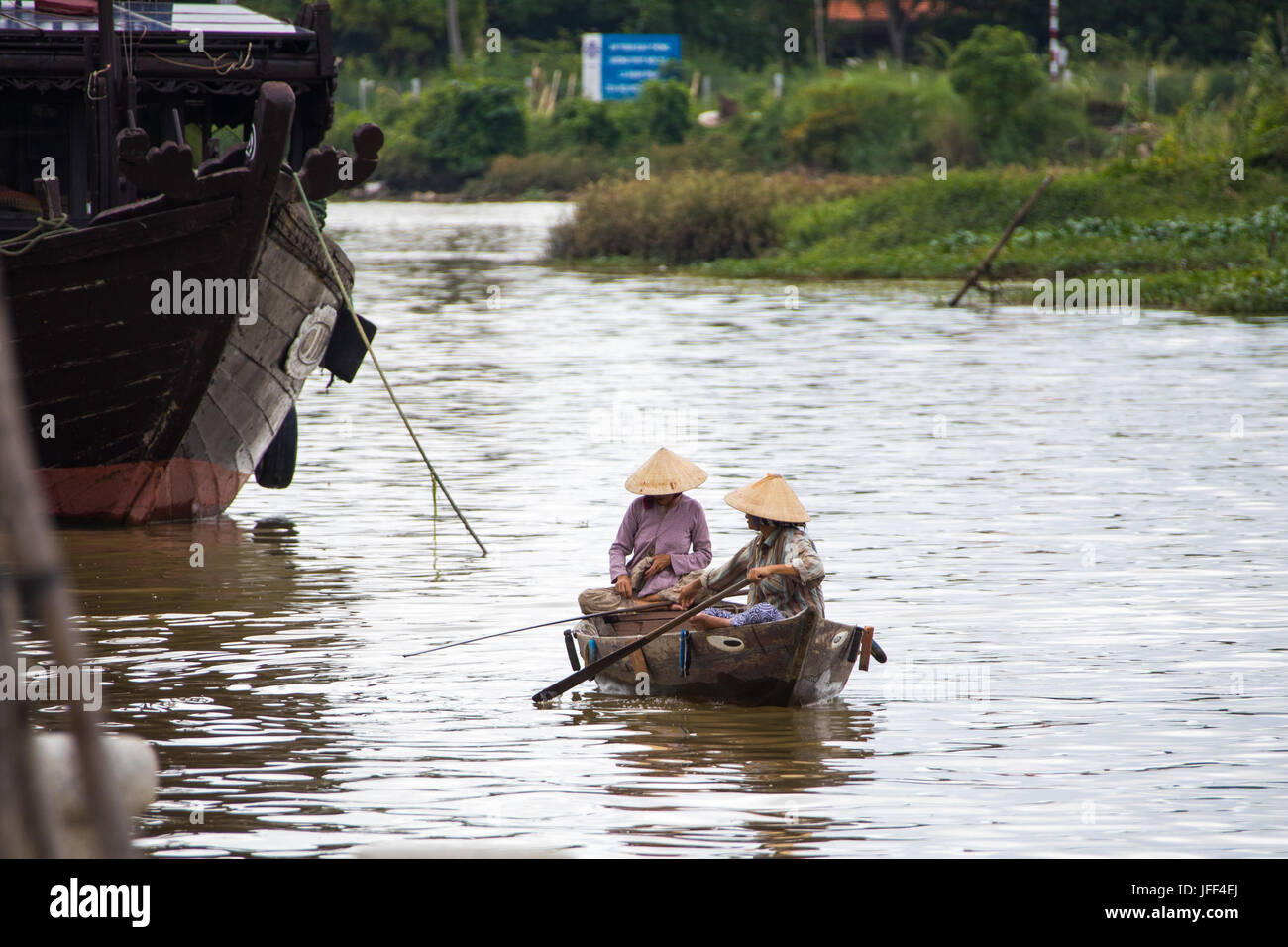Mujer en una lancha lookoing para clientela turística en el río Thu Bon en Hoi An, Vietnam Foto de stock